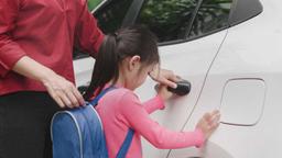 A mom dropping her kid off to a car